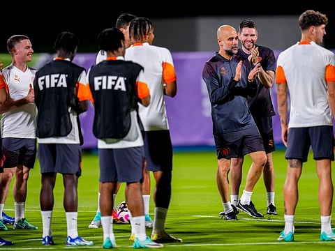 Manchester City's head coach Pep Guardiola applauds next to his players during a training session at the King Abdullah Sports City Stadium in Jeddah recently.