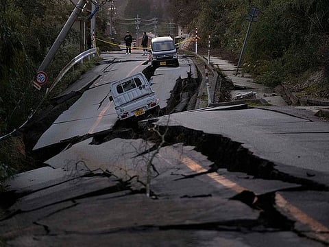 Bystanders look at damages somewhere near Noto town in the Noto peninsula facing the Sea of Japan.