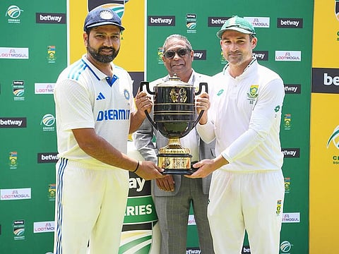 India's Rohit Sharma (L) and South Africa's Dean Elgar (R) hold the cup after South Africa and India drew the series at Newlands stadium in Cape Town on January 4, 2024.  