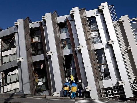 Police officers check a collapsed building in the city of Wajima, Ishikawa prefecture, on January 5, 2024, after a major 7.5 magnitude earthquake struck the Noto region on New Year's Day.  
