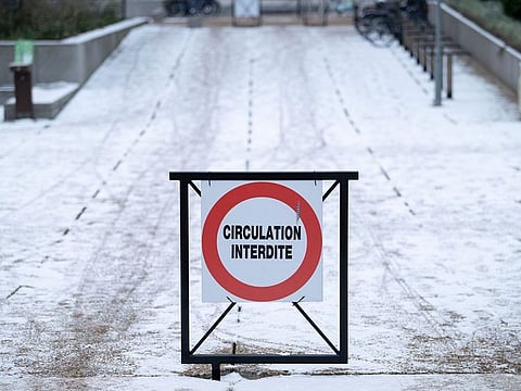 A sign reading 'Traffic Prohibited' on snow-covered ground in La Defense business district during freezing temperatures in Paris, France.