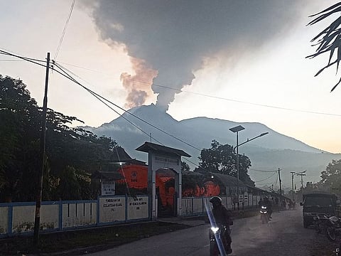 Motorists ride as mount Lewotobi Laki-Laki spews hot smoke in Flores Timur, Nusa Tenggara, Timur province on January 2, 2024.