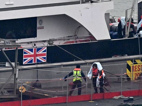 Migrants with children, some of the first in 2024 to be picked up at sea attempting to cross the English Channel from France, disembark from the UK Border Force Cutter 'Typhoon', at the Marina in Dover southeast England, on January 13, 2024.  