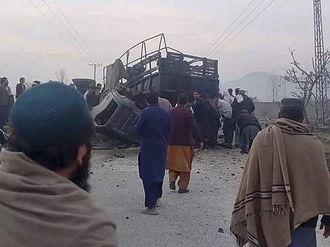 Rescue workers inspect a damaged police vehicle at the site of bomb explosion, in Mamund, Pakistan, on January 8, 2024.  The South Asian nation of 240 million has seen an uptick in attacks along its border regions since the Taliban surged back to power there in 2021, and has consistently claimed Kabul is giving safe haven to militants.