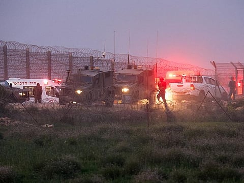 Israeli soldiers walk next to military vehicles and ambulances, as the conflict continues between Israel and the Palestinian Islamist group Hamas, near the fence on the Israeli border with Gaza, on January 22, 2024. 