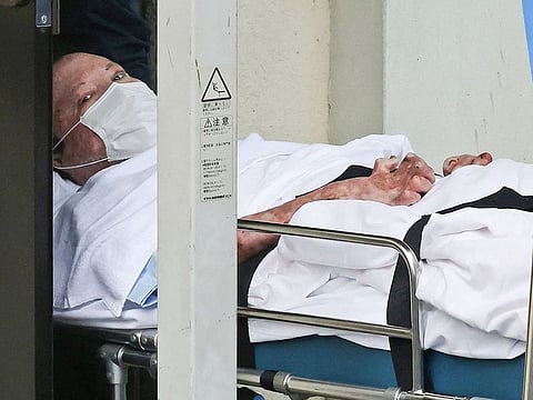 Shinji Aoba, who is suspected of the Kyoto Animation studio arson attack, looks up as he is transported on a stretcher to the Fushimi police station in Kyoto on May 27, 2020. 