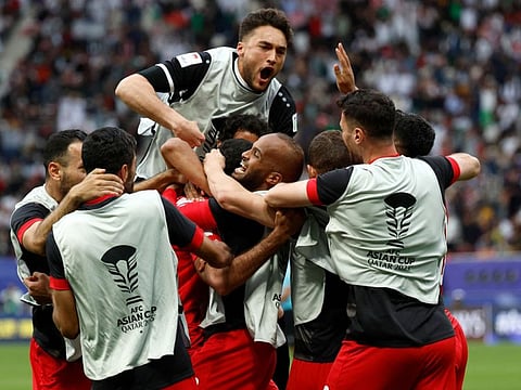 Jordan's players celebrate their win in the Qatar 2023 AFC Asian Cup match against Iraq at Khalifa International Stadium in Doha on Monday.