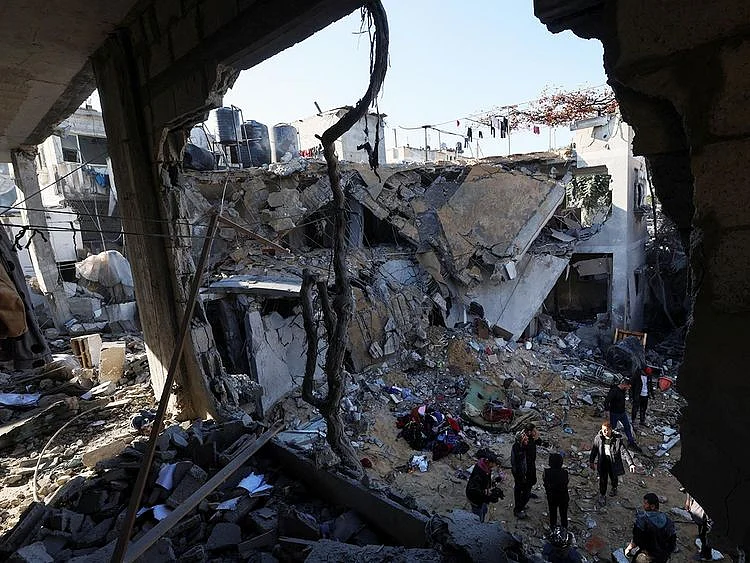Palestinians inspect the site of an Israeli strike in Rafah in the southern Gaza Strip on February 3, 2024. 