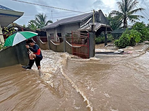 A man wades through floodwaters brought about by heavy rains at a residential neighbourhood in Propseridad town, Agusan del Sur province on southern Mindanao island.