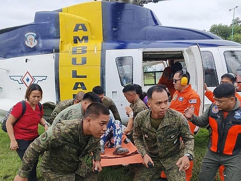 This handout photo taken and released on February 7, 2024 by the Philippine Army's 60th Infantry "Mediator" Battalion shows Philippine soldiers transferring a landslide survivor from a helicopter to an ambulance following a medical evacuation flight from Maco to the Davao Regional Medical Center in Tagum, Davao del Norte province. 