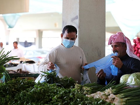 A man buys vegetables at a market in Qatif, Saudi Arabia. Jeddah wholesale market is full of expatriates unlawfully involved in business deals.