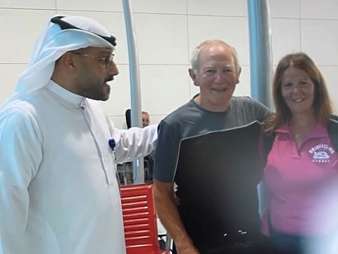 Duty officer Mohammed Sohrabi with the reunited couple at Dubai airport. 