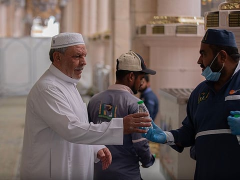 Workers hand out bottles of Zamzam water to worshippers at the Prophet's Mosque in Saudi Arabia.
