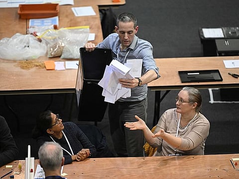 Ballots are emptied from a ballot box as the count gets underway at the counting centre at Kettering Leisure Village, in Kettering, central England, on February 15, 2024, during the UK Parliamentary by-election for the Wellingborough constituency. 