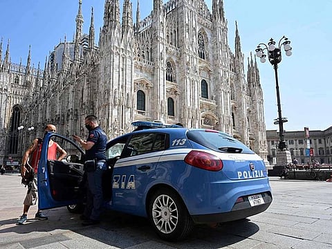 A police car stands in front of the Cathedral (Duomo di Milano) in Milan on August 12, 2020. 