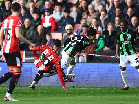 Sheffield United's Mason Holgate fouls Brighton & Hove Albion's Kaoru Mitoma before being shown a red card during a Premier League match at Bramall Lane, Sheffield, Britain, on Sunday.