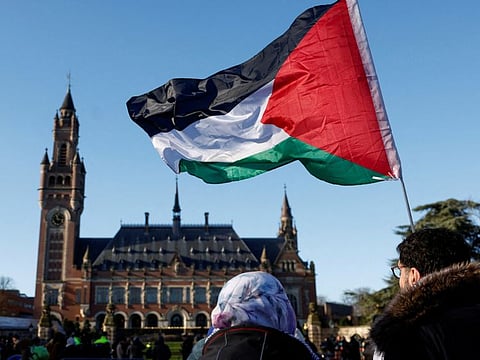 Protesters hold a Palestinian flag as they gather outside the International Court of Justice (ICJ). In December 2022, the UN General Assembly asked the ICJ for a non-binding “advisory opinion” on the “legal consequences arising from the policies and practices of Israel in the Occupied Palestinian Territory, including East Jerusalem.”