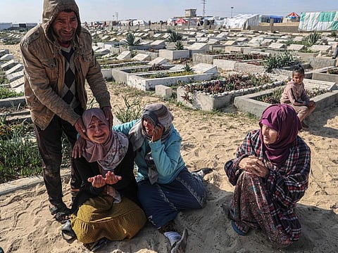 Relatives mourn during the funeral of loved ones killed during overnight Israeli strikes at a cemetery in Rafah, on the southern Gaza Strip on February 21, 2024, amid ongoing battles between Israel and the militant Hamas movement.  