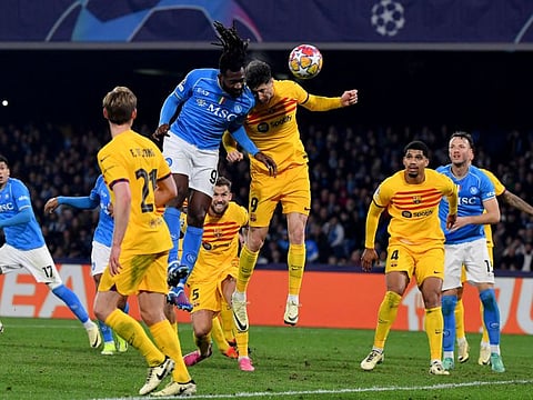 TOPSHOT - Napoli's Cameroon midfielder #99 Andre Zambo Anguissa (C-L) vies with Barcelona's Polish forward #09 Robert Lewandowski (C-R) during the UEFA Champions League round of 16 first Leg football match between Napoli and Barcelona at the Diego-Armando-Maradona stadium in Naples on February 21, 2024. (Photo by Tiziana FABI / AFP)