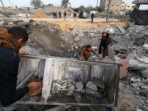 People check the destruction caused by overnight Israeli bombardment in Rafah in the southern Gaza Strip on February 23, 2024, as battles between Israel and the Palestinian militant group Hamas continue.  