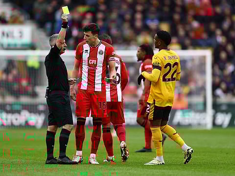 Wolverhampton Wanderers' Nelson Semedo is shown a yellow card by referee Darren Bond during a Premier League match against Sheffield United at Molineux Stadium, Wolverhampton, Britain on Sunday.