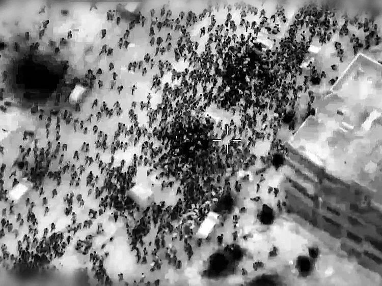This image grab from a handout video released by the Israeli army on February 29, 2024, shows what the army says are Gazans around aid trucks in Gaza City.   