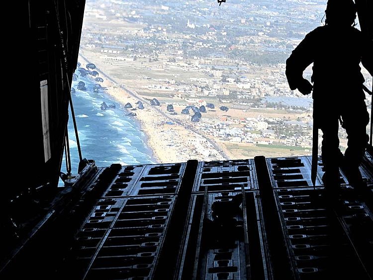 A US Air Force loadmaster releases humanitarian aid pallets of food and water over Gaza, on March 2, 2024.  