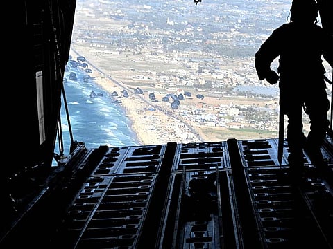 A US Air Force loadmaster releases humanitarian aid pallets of food and water over Gaza, on March 2, 2024.  