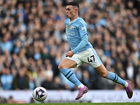 TOPSHOT - Manchester City's English midfielder Phil Foden runs with the ball during the English Premier League football match against Manchester United at the Etihad Stadium in Manchester on Sunday.