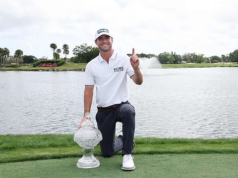 Austin Eckroat of the United States celebrates with the trophy The Cognizant Classic in The Palm Beaches at PGA National Resort And Spa on Monday.