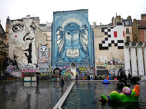 A mosaic by French artist Invader, top right, is seen on a street of Paris.