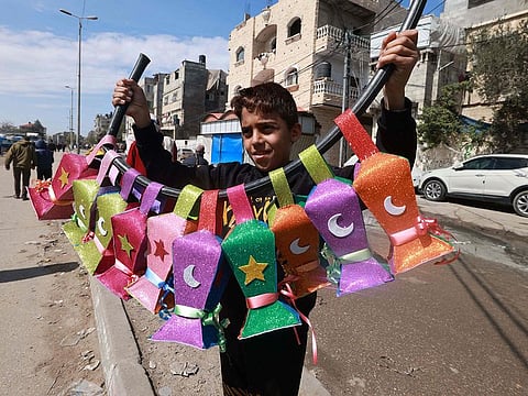 A displaced Palestinian child sells handmade Ramadan lanterns in Rafah in the southern Gaza Strip on March 8, 2024, amid the ongoing conflict between Israel and Hamas militants, as Muslim worshippers prepare to welcome the fasting month of Ramadan which begins next week. 