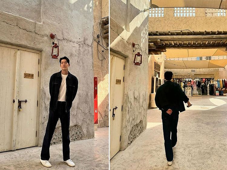 Kim Woo-bin poses against the backdrop of Al Seef's traditional architecture.