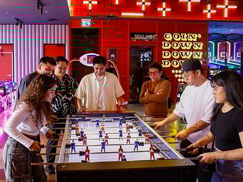 A group of friends from the Philippines and India play soccer table in Brass Monkey, Dubai.  