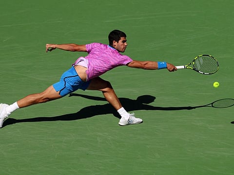 Carlos Alcaraz of Spain stretches to play a backhand against Fabian Marozsan of Hungary in their fourth round match during the BNP Paribas Open at Indian Wells Tennis Garden on Tuesday.
