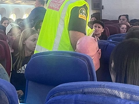 A paramedic walks onboard as passengers look on, after an incident on a LATAM Airlines Boeing 787, in Auckland, New Zealand, March 11, 2024, in this picture obtained from social media. 