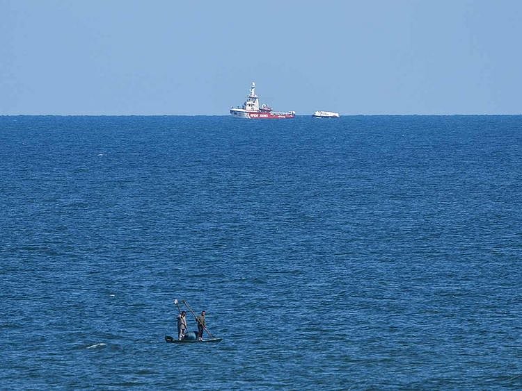 A ship belonging to the Open Arms aid group approaches the shores of Gaza towing a barge with 200 tons of humanitarian aid on Friday, March 15, 2024. 