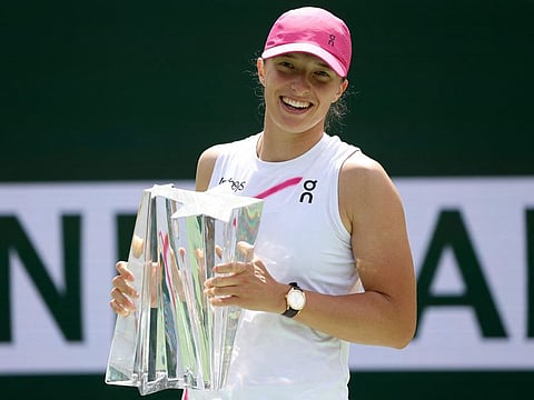 Iga Swiatek of Poland poses with the trophy after winning the Women's Final of the BNP Paribas Open at Indian Wells Tennis Garden on Sunday.