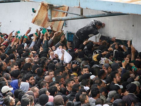 Palestinians gather to receive aid outside an UNRWA warehouse as Gaza residents face crisis levels of hunger, amid the ongoing conflict between Israel and Hamas, in Gaza City, on March 18, 2024.  
