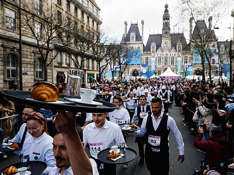 Waiters and waitresses in work outfits take the start of a traditionnal "Course des cafes" (the cafes' race), in front of the City Hall in central Paris.