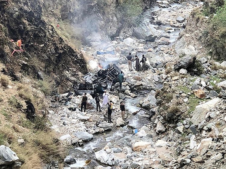 Security officials inspect the wreckage of a vehicle which was carrying Chinese engineers that plunged into a deep ravine off the mountainous Karakoram Highway after a suicide attack near Besham city in the Shangla district of Khyber Pakhtunkhwa province on March 26, 2024.  