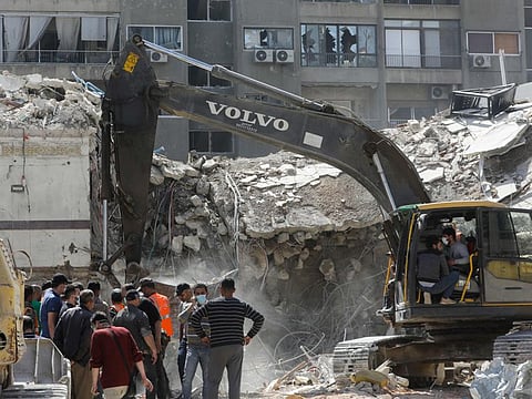 Rescue workers search in the rubble of a building annexed to the Iranian embassy a day after an air strike in Damascus on April 2, 2024.  