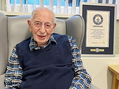 John Tinniswood, 111, poses with his certificate from the Guinness World Records, who announced that he is the world's oldest living man, in Southport, Britain. 