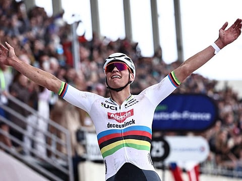 Mathieu Van Der Poel celebrates as he cycles past the finish line to win the 121st edition of the Paris-Roubaix one-day classic cycling race on Sunday.