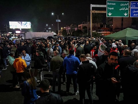 Partisans of the Christian Lebanese Forces party block the main Byblos-Beirut highway to protest the killing of a local politician in the Jbeil (Byblos) area, on April 8, 2024.  