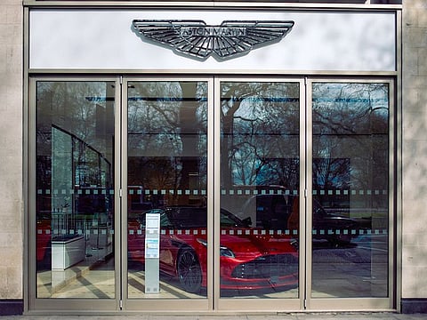 A sign is pictured above the entrance to the Aston Martin luxury car dealership on Park Lane in central London on April 11, 2024. 
