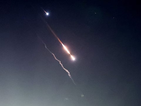 Objects are seen in the sky above Jerusalem after Iran launched drones and missiles towards Israel on April 14, 2024. 