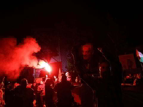 An Iranian man holds a poster of senior Iranian military commander General Qassem Soleimani during a celebration after the IRGC attack on Israel, in Tehran, on April 14, 2024.  
