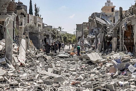 People search through the rubble of a collapsed building in the eastern side of the Maghazi camp for Palestinian refugees in the central Gaza Strip on April 15, 2024. 