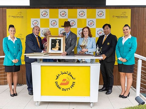 Remarquees owner Julian Richmond Watson, acoompanied by his wife, receives the trophy for the Dubai Duty Free Stakes from Colm McLoughlin last year.